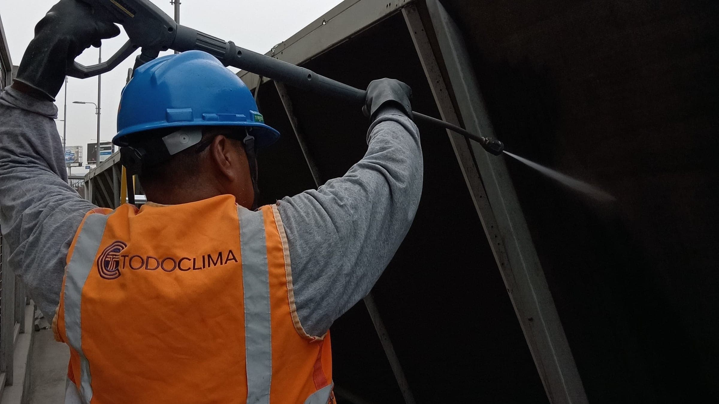 Técnico de Grupo TodoClima hidrolavando el condensador de un chiller durante un mantenimiento preventivo.