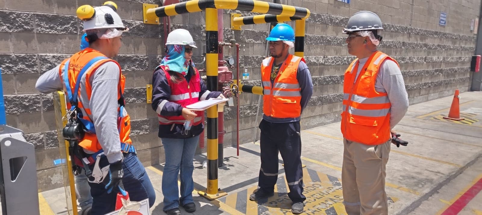 Equipo de Grupo TodoClima en una charla de seguridad en planta, con chalecos reflectantes y casco, revisando el procedimiento antes de intervenir.